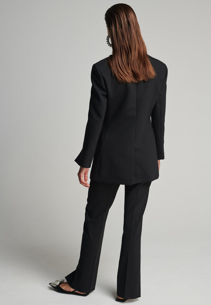 Sharp-tailored blazer in black. Features shoulder-pads, pockets, and cuffs opening. True to size.