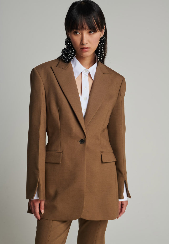 Sharp-tailored blazer in camel. Features shoulder-pads, pockets, and cuff opening. True to size.