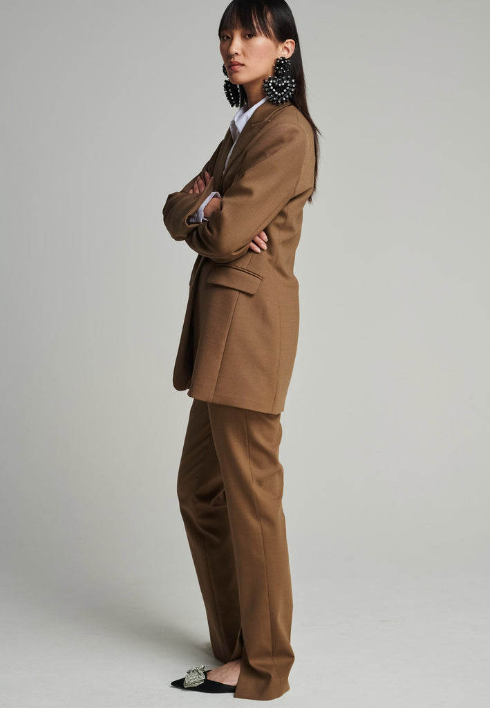 Sharp-tailored blazer in camel. Features shoulder-pads, pockets, and cuff opening. True to size.