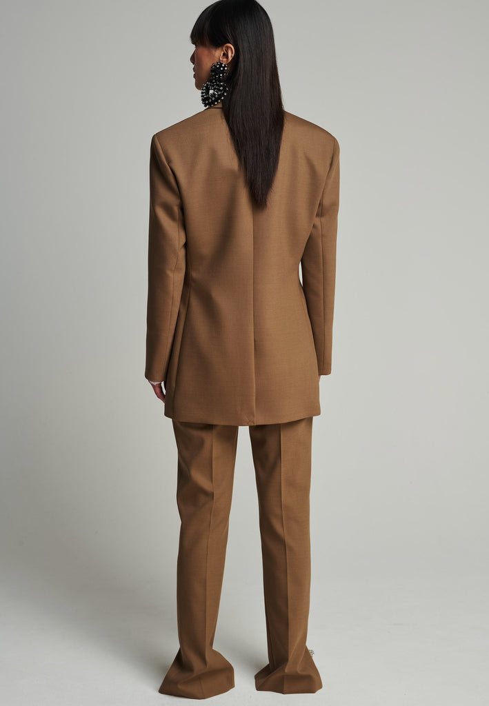 Sharp-tailored blazer in camel. Features shoulder-pads, pockets, and cuff opening. True to size.