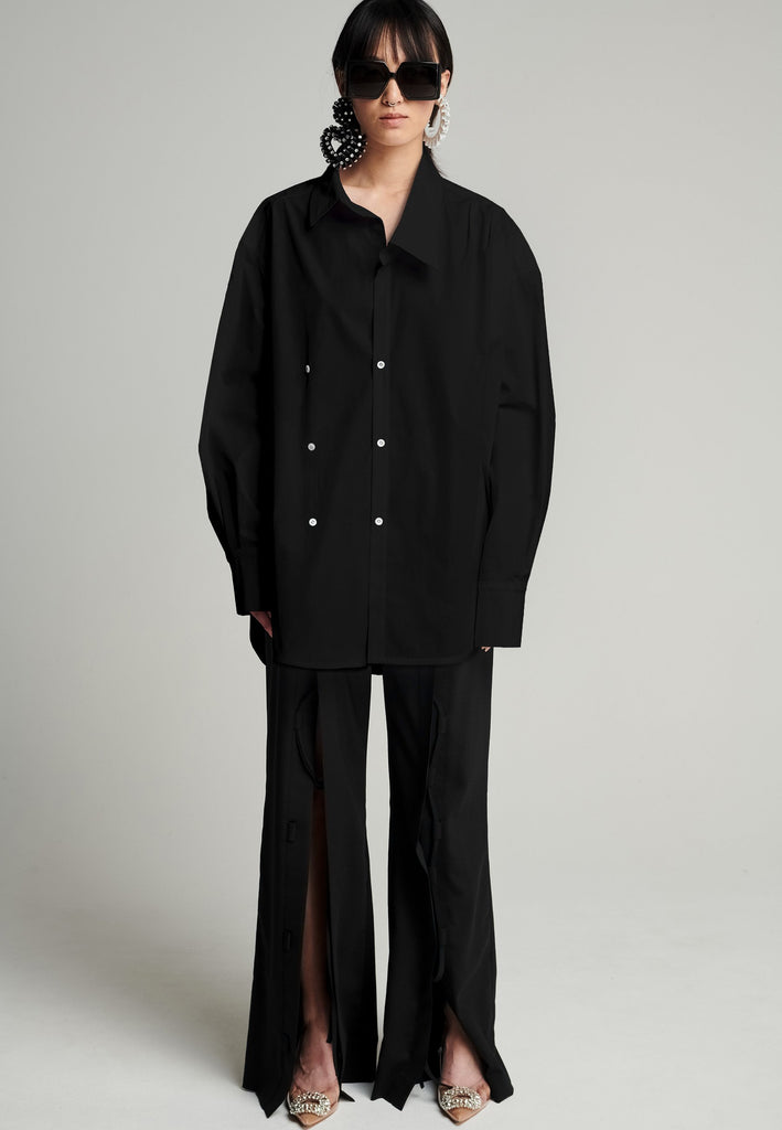 Menswear-inspired asymmetric wrap-shirt. Features two rows of buttons that can be fastened in two different widths. 2 in 1. Pleated on one shoulder. Fits oversize.