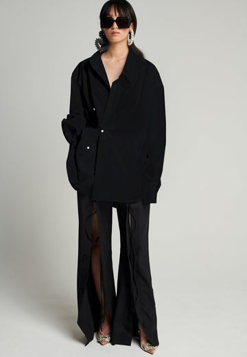 Menswear-inspired asymmetric wrap-shirt. Features two rows of buttons that can be fastened in two different widths. 2 in 1. Pleated on one shoulder. Fits oversize.