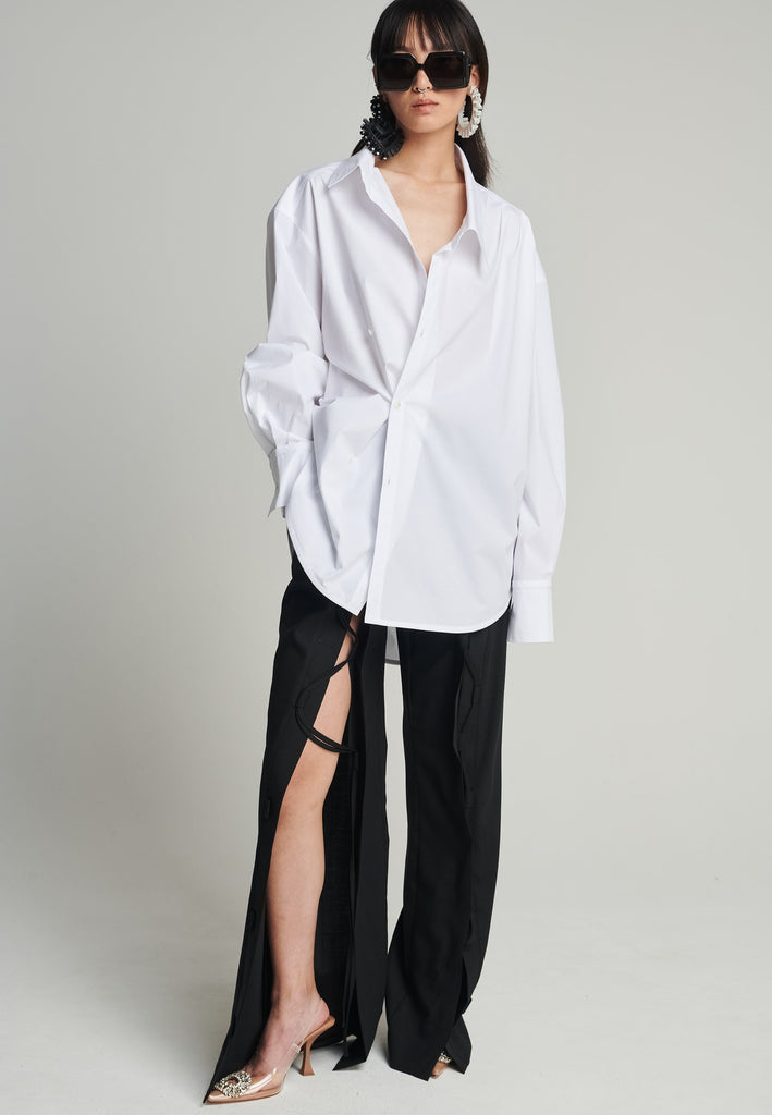 Menswear-inspired asymmetric wrap-shirt. Features two rows of buttons that can be fastened in two different widths. 2 in 1. Pleated on one shoulder. Fits oversize.