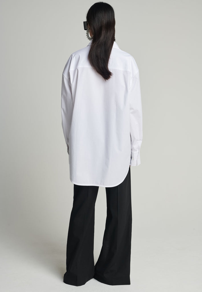 Menswear-inspired asymmetric wrap-shirt. Features two rows of buttons that can be fastened in two different widths. 2 in 1. Pleated on one shoulder. Fits oversize.