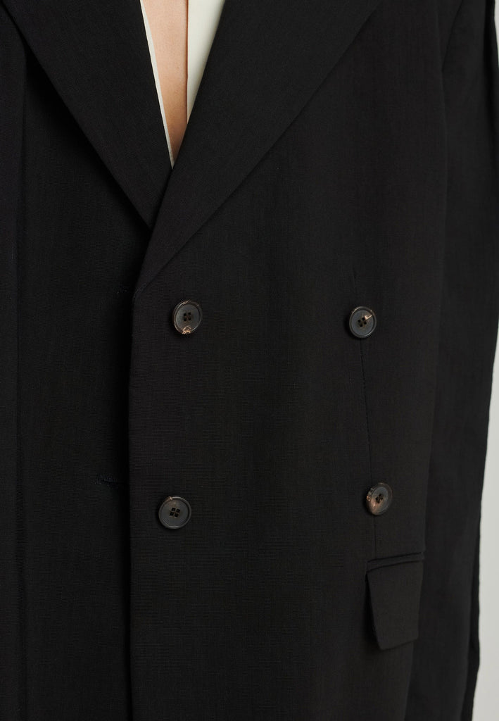 Wide-shouldered blazer in black. Features shoulder-pads, front pockets, and a belt to adjust to your liking. Fits oversize.