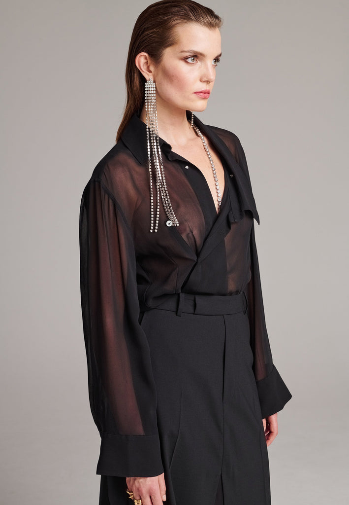 Wide-shouldered wrap shirt fitted at the waist. Asymmetric collar structure. Wide relaxed sleeves with multiple buttons on the cuff to adjust the width. Wear it tight or wide. Detailed with darts at the waistline and six-hole buttons. Cut from silk georgette.