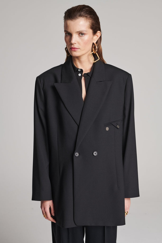 Wide-shouldered blazer in classic wool with an insideout back. Features shoulder pads and a fully lined back. Fits oversized.