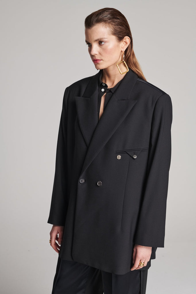 Wide-shouldered blazer in classic wool with an insideout back. Features shoulder pads and a fully lined back. Fits oversized.