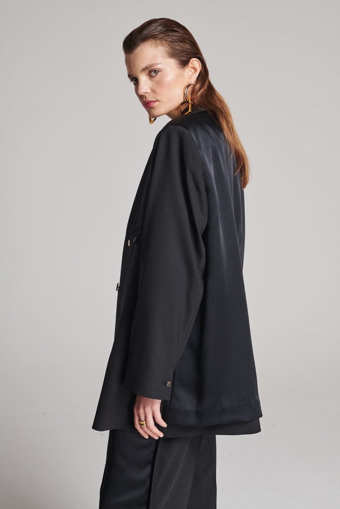 Wide-shouldered blazer in classic wool with an insideout back. Features shoulder pads and a fully lined back. Fits oversized.