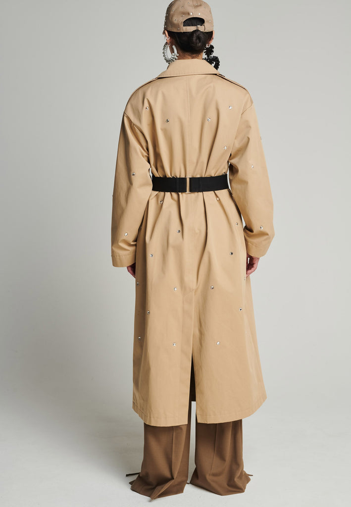 Cotton trenchcoat in camel. Features Swarovski diamonds, pockets, and a single vent. Fits oversize.