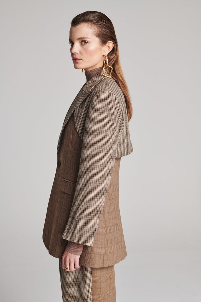 Shoulder-padded fitted blazer. Cut from the finest checked suiting wool blend. Features two checked fabrics miraculosly combined in one design. Detailed with a check double layer at the front top panel and back. True to size.