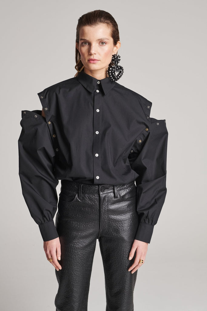 Wide-shouldered shirt with button fly-front. Features a batwing armhole with a detachable shoulder ruffle. Detailed with gold and silver press buttons, use them to separate the shirt's arms. Fits oversize.