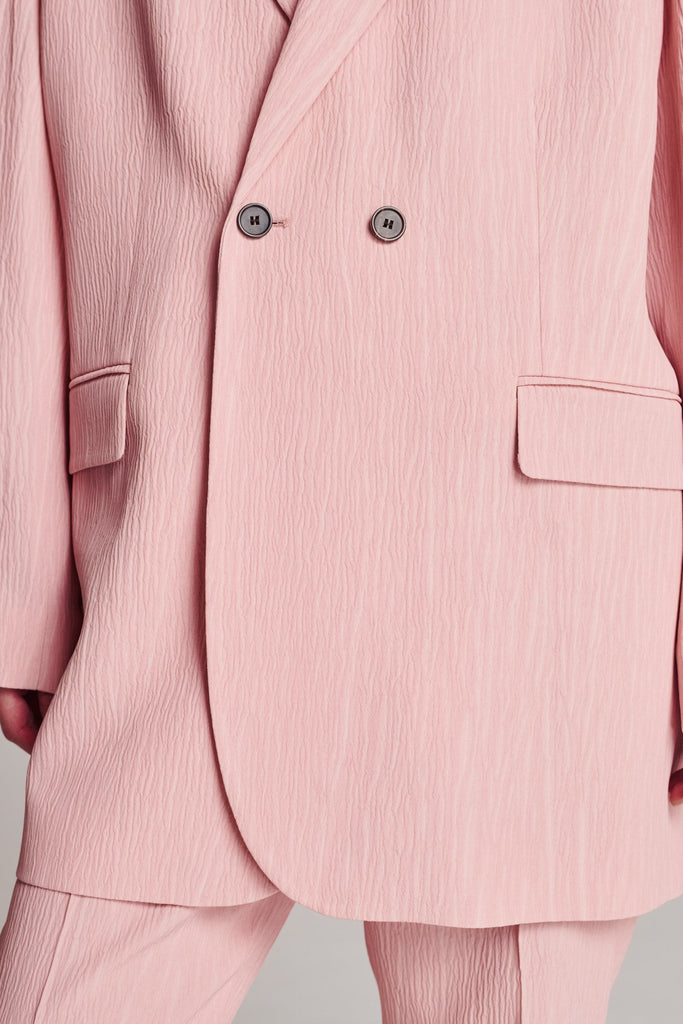Wide-shouldered blazer, fluid and loose for complete comfort. Features shoulder pads and plisse details. Fits oversized.