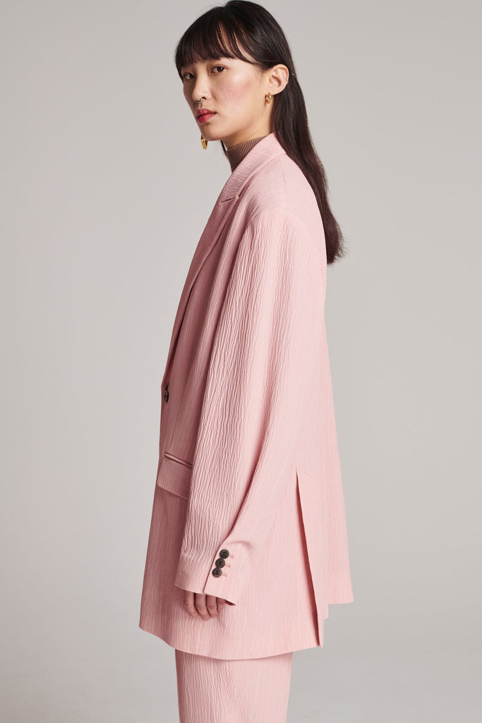 Wide-shouldered blazer, fluid and loose for complete comfort. Features shoulder pads and plisse details. Fits oversized.