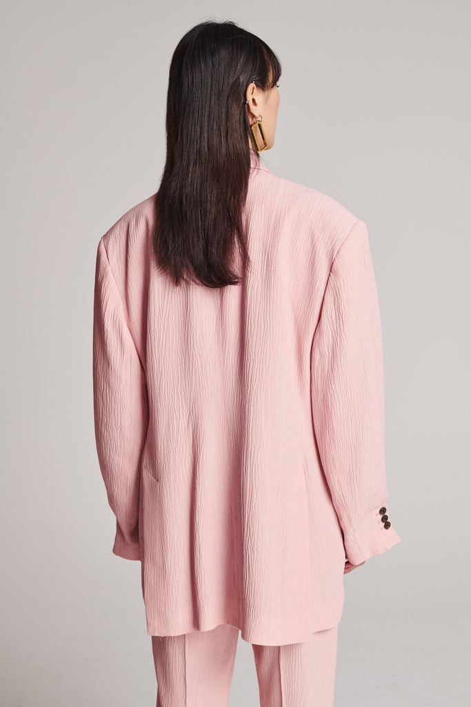 Wide-shouldered blazer, fluid and loose for complete comfort. Features shoulder pads and plisse details. Fits oversized.