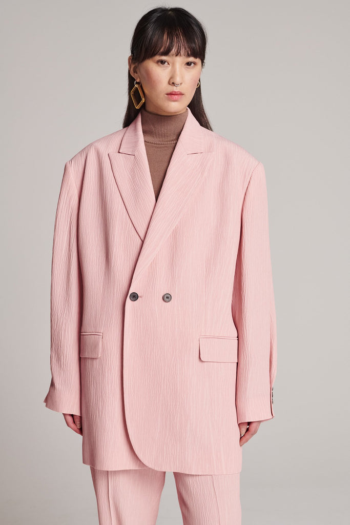Wide-shouldered blazer, fluid and loose for complete comfort. Features shoulder pads and plisse details. Fits oversized.
