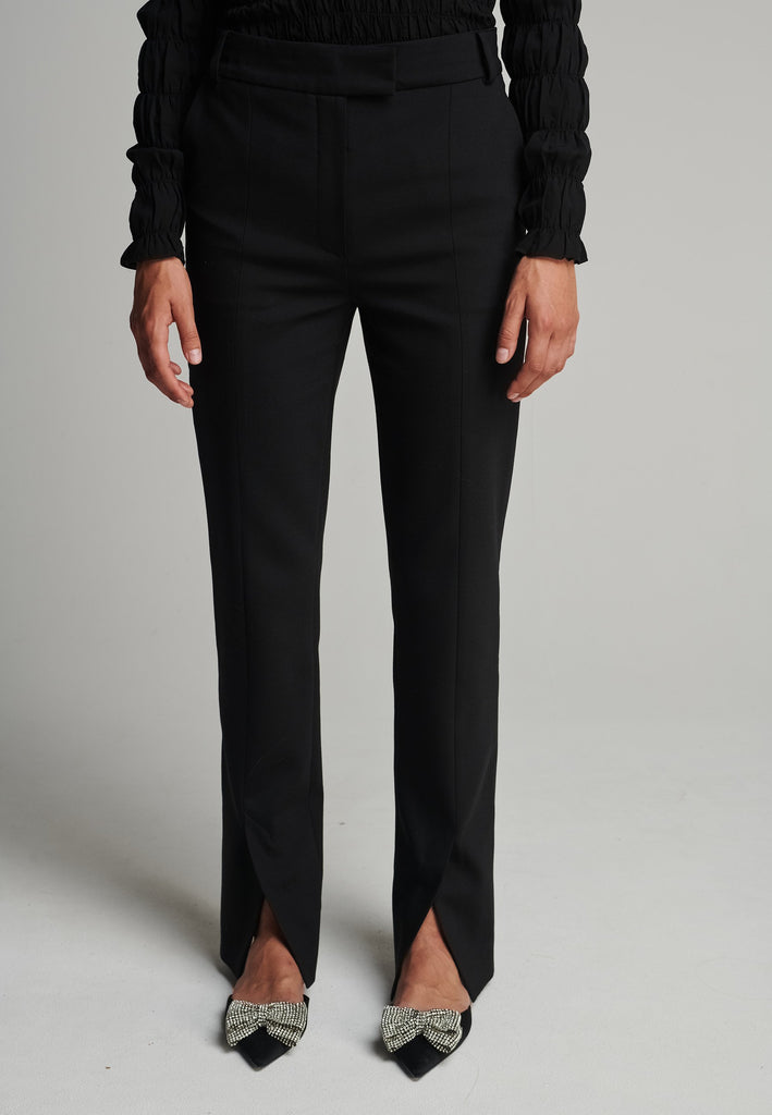 Slim pants in black. Features pockets, belt loops, pressed front pleats, and na ankle opening. True to size.