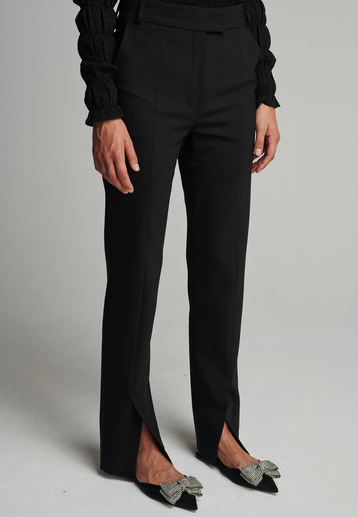 Slim pants in black. Features pockets, belt loops, pressed front pleats, and na ankle opening. True to size.