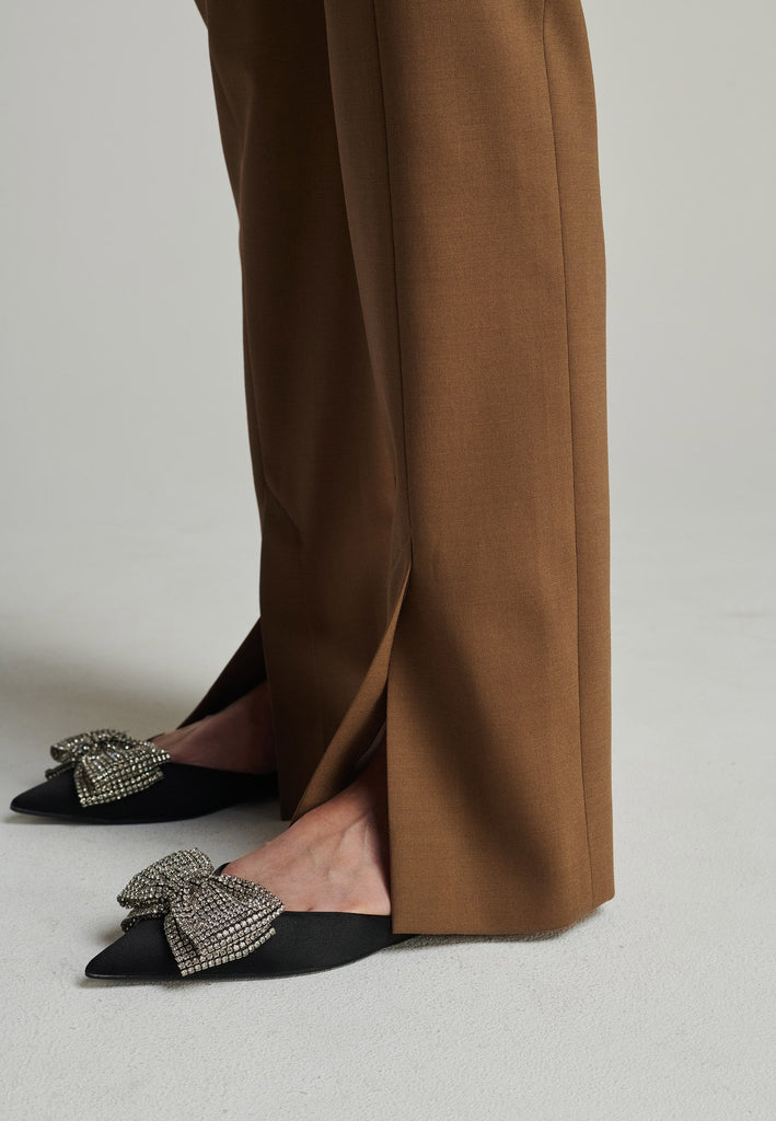 Slim pants in camel. Features pockets, belt loops, pressed front pleats, and na ankle opening. True to size.
