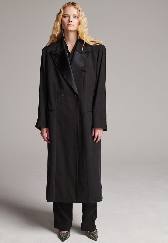 An effortless coat to slip over any outfit, the LONG coat is made from a linen blend with a wrinkle washed look. Detailed by sharp shoulder-pads, double-breast fitting, square hole horn buttons and satin lapel finish with needle stitching. The ankle-grazing length emphasizes the loose fit and the effortless cool over tailoring. FRENKEN makes dressing-up every morning easier.