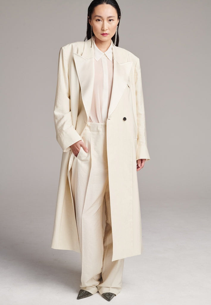 An effortless coat to slip over any outfit, the LONG coat is made from a linen blend with a wrinkle-washed look. Detailed by sharp shoulder pads, double-breast fitting, square hole horn buttons and satin lapel finish with needle stitching. The ankle-grazing length emphasizes the loose fit and the effortless cool over tailoring. FRENKEN makes dressing up every morning easier.