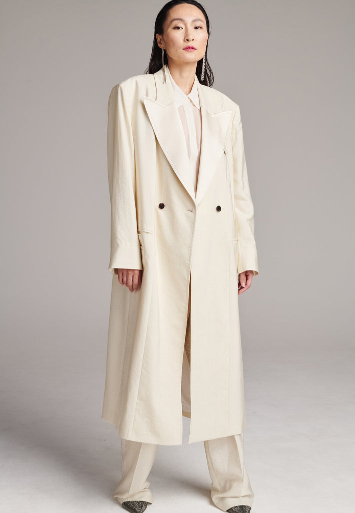 An effortless coat to slip over any outfit, the LONG coat is made from a linen blend with a wrinkle-washed look. Detailed by sharp shoulder pads, double-breast fitting, square hole horn buttons and satin lapel finish with needle stitching. The ankle-grazing length emphasizes the loose fit and the effortless cool over tailoring. FRENKEN makes dressing up every morning easier.