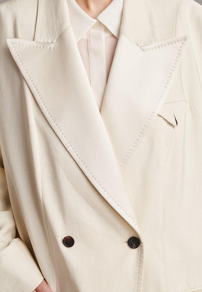 An effortless coat to slip over any outfit, the LONG coat is made from a linen blend with a wrinkle-washed look. Detailed by sharp shoulder pads, double-breast fitting, square hole horn buttons and satin lapel finish with needle stitching. The ankle-grazing length emphasizes the loose fit and the effortless cool over tailoring. FRENKEN makes dressing up every morning easier.