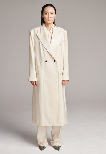 An effortless coat to slip over any outfit, the LONG coat is made from a linen blend with a wrinkle-washed look. Detailed by sharp shoulder pads, double-breast fitting, square hole horn buttons and satin lapel finish with needle stitching. The ankle-grazing length emphasizes the loose fit and the effortless cool over tailoring. FRENKEN makes dressing up every morning easier.