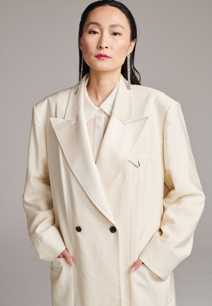 An effortless coat to slip over any outfit, the LONG coat is made from a linen blend with a wrinkle-washed look. Detailed by sharp shoulder pads, double-breast fitting, square hole horn buttons and satin lapel finish with needle stitching. The ankle-grazing length emphasizes the loose fit and the effortless cool over tailoring. FRENKEN makes dressing up every morning easier.