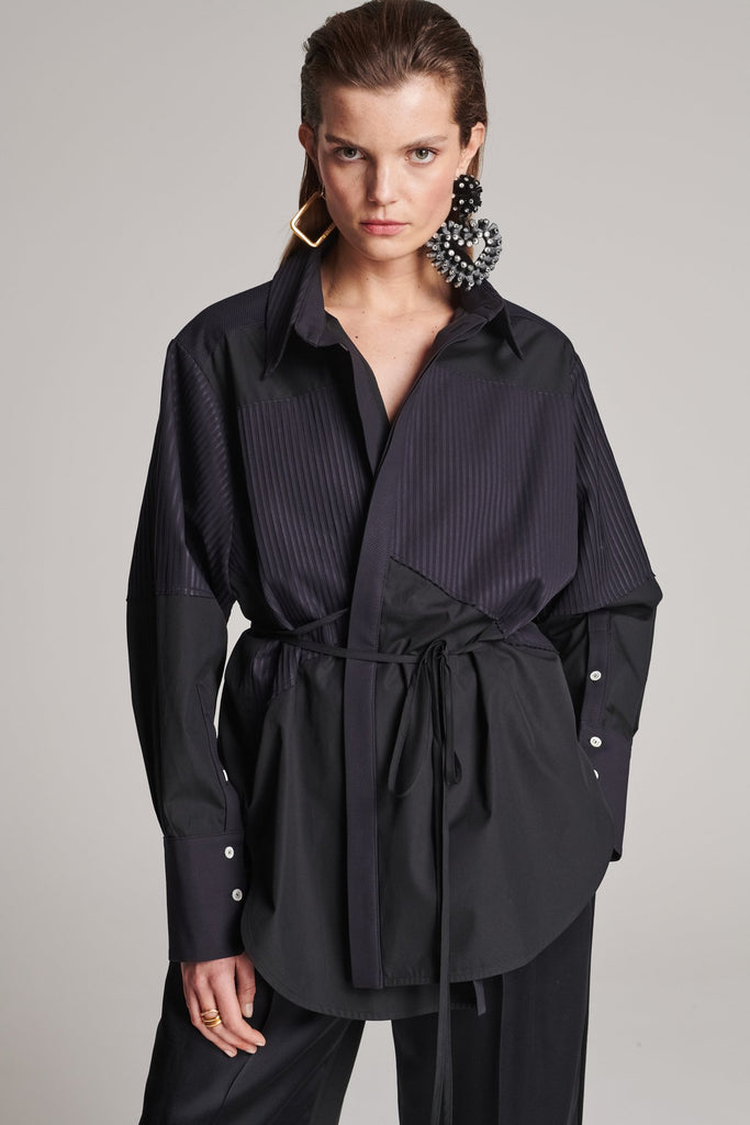 Menswear-inspired shirt. Features plisse details at the top front panel and back. Detailed with a classic collar stand, a concealed button fly-front and a string belt to adjust to your liking. Fits oversize.