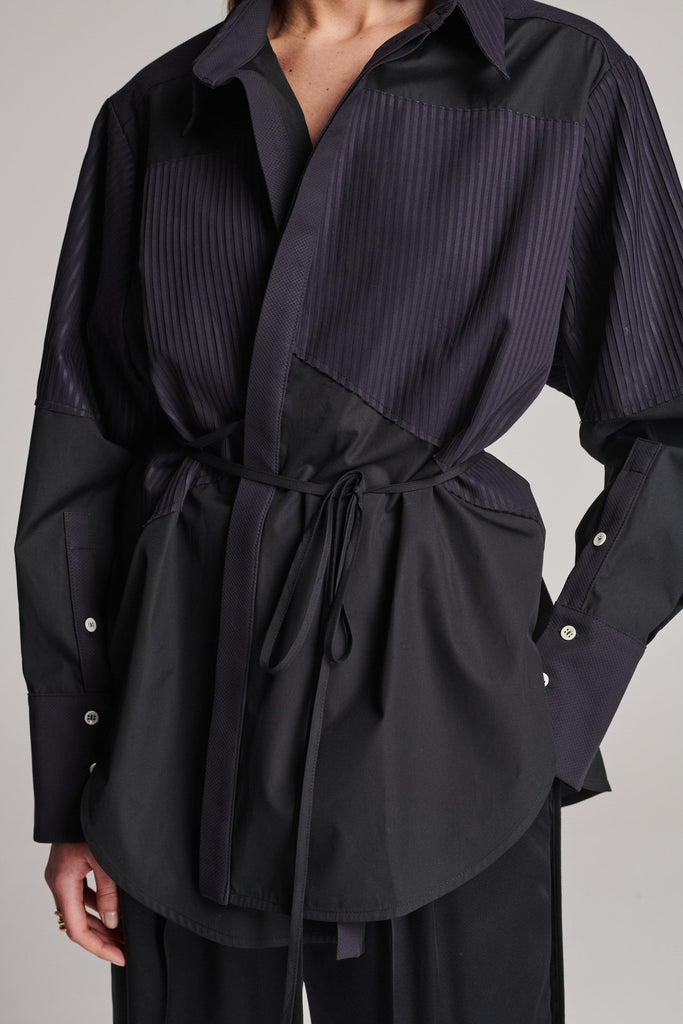 Menswear-inspired shirt. Features plisse details at the top front panel and back. Detailed with a classic collar stand, a concealed button fly-front and a string belt to adjust to your liking. Fits oversize.
