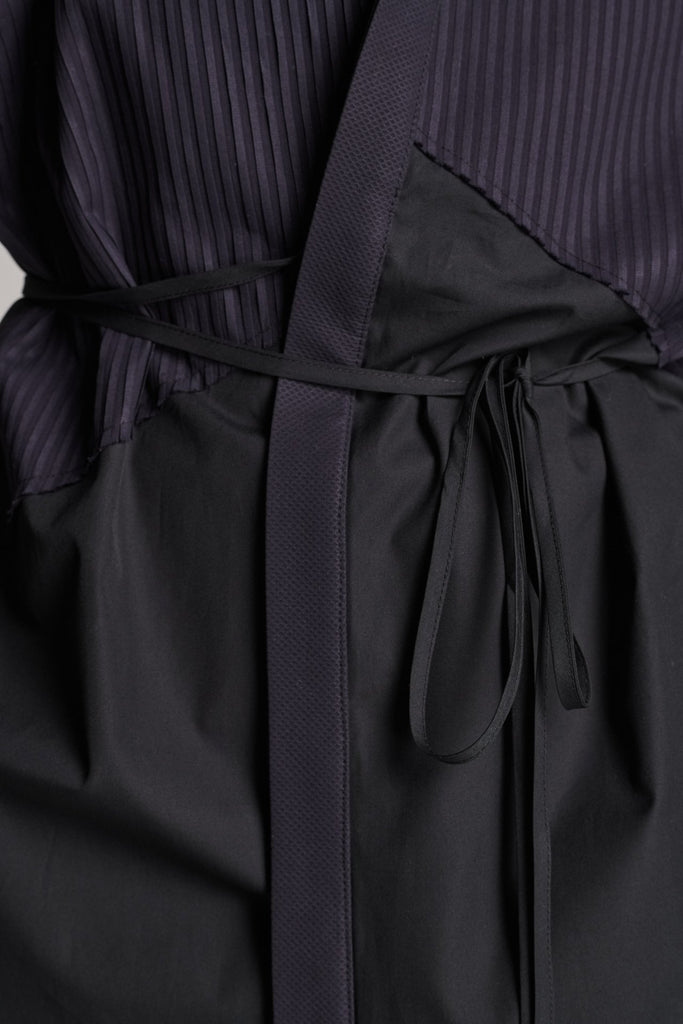 Menswear-inspired shirt. Features plisse details at the top front panel and back. Detailed with a classic collar stand, a concealed button fly-front and a string belt to adjust to your liking. Fits oversize.