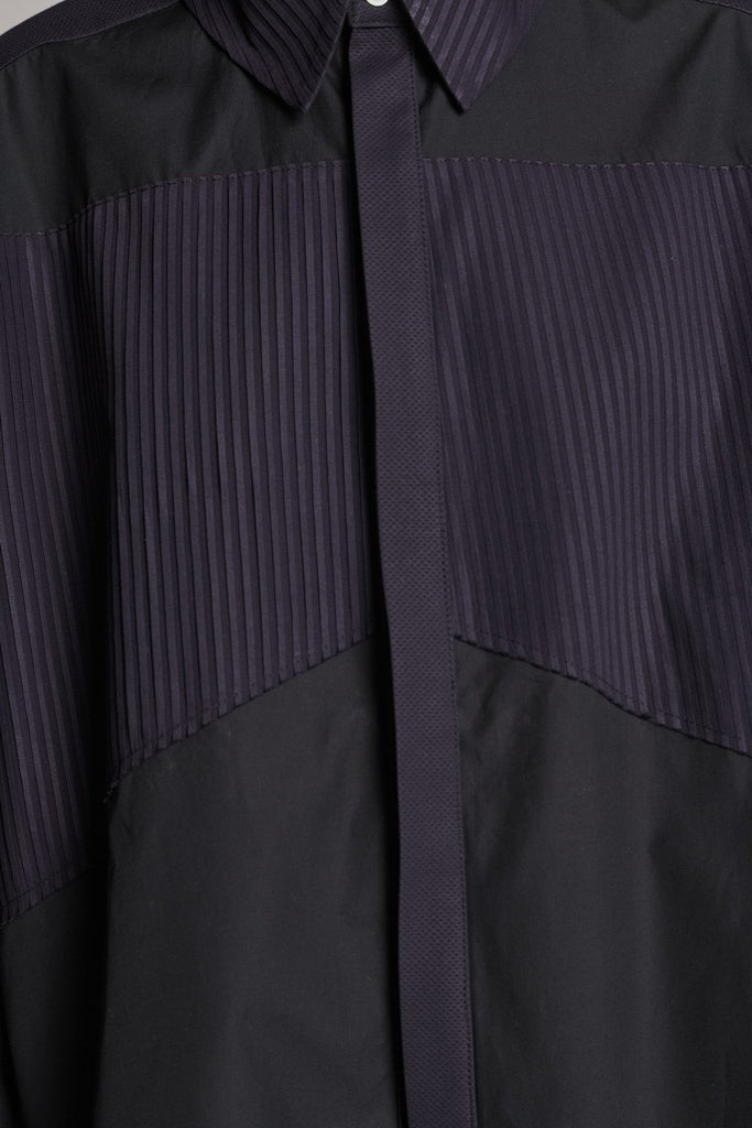Menswear-inspired shirt. Features plisse details at the top front panel and back. Detailed with a classic collar stand, a concealed button fly-front and a string belt to adjust to your liking. Fits oversize.