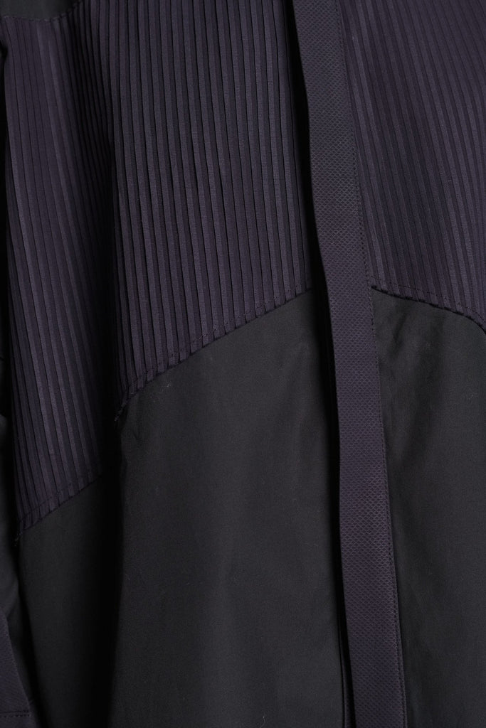 Menswear-inspired shirt. Features plisse details at the top front panel and back. Detailed with a classic collar stand, a concealed button fly-front and a string belt to adjust to your liking. Fits oversize.