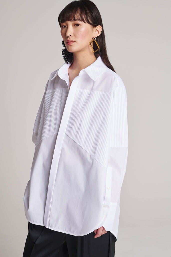 Menswear-inspired shirt. Features plisse details at the top front panel and back. Detailed with a classic collar stand, a concealed button fly-front and a string belt to adjust to your liking. Fits oversize.