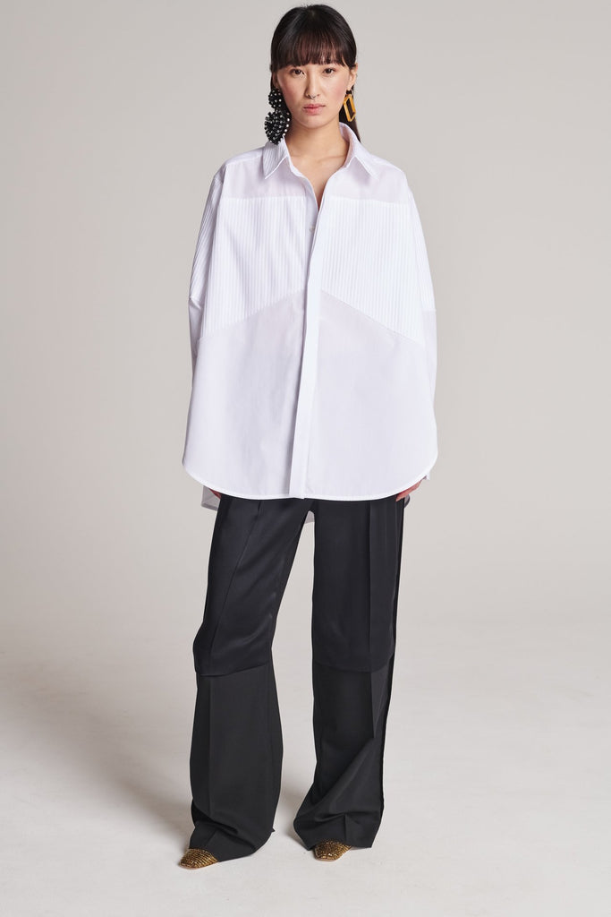 Menswear-inspired shirt. Features plisse details at the top front panel and back. Detailed with a classic collar stand, a concealed button fly-front and a string belt to adjust to your liking. Fits oversize.