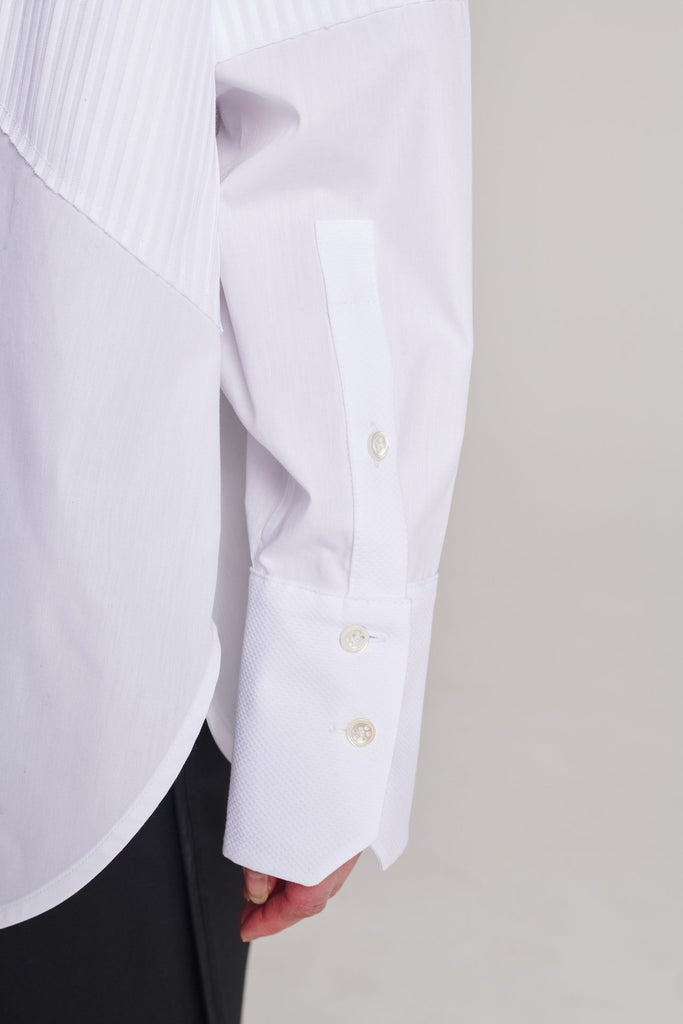 Menswear-inspired shirt. Features plisse details at the top front panel and back. Detailed with a classic collar stand, a concealed button fly-front and a string belt to adjust to your liking. Fits oversize.