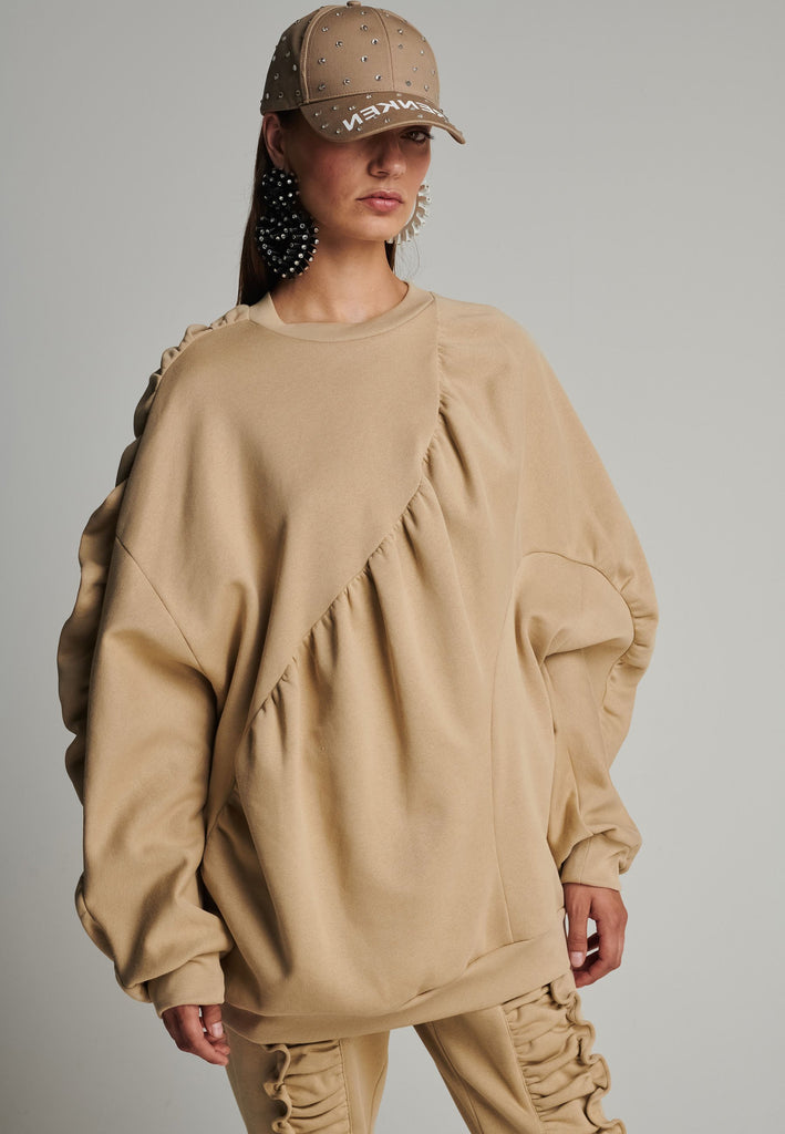 Cotton batwing sleeve sweater in camel. Features na wrinkled effect, and elastic cuffs. Fits oversize.