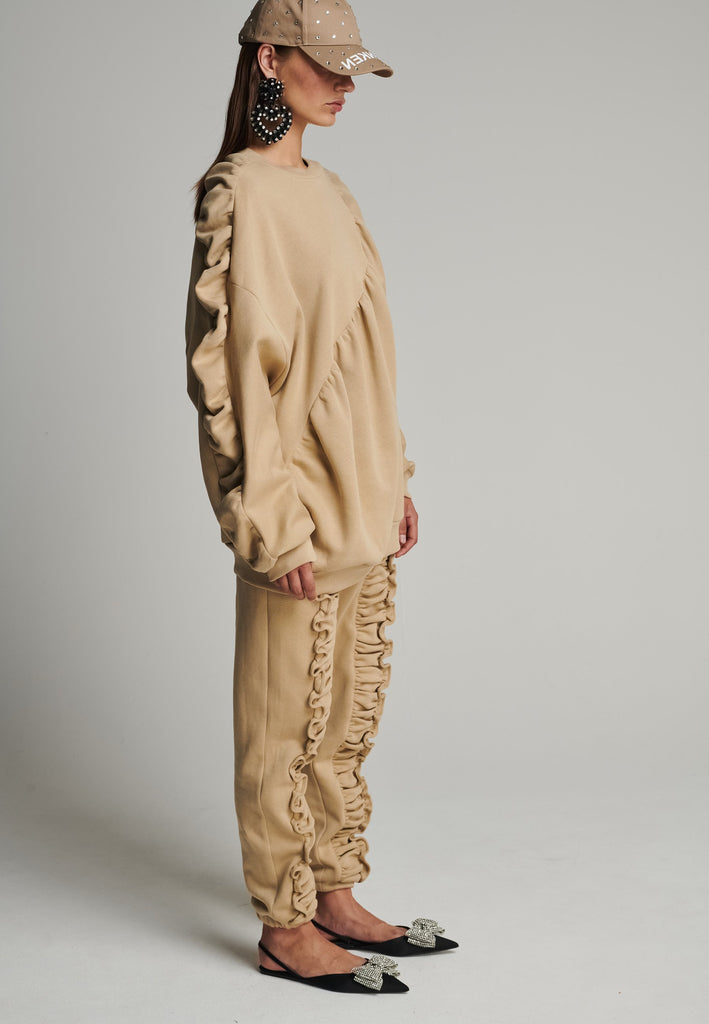 Cotton batwing sleeve sweater in camel. Features na wrinkled effect, and elastic cuffs. Fits oversize.