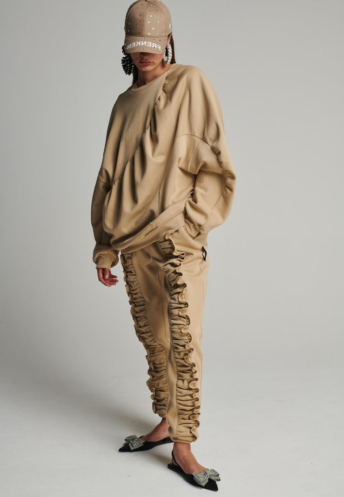 Cotton batwing sleeve sweater in camel. Features na wrinkled effect, and elastic cuffs. Fits oversize.