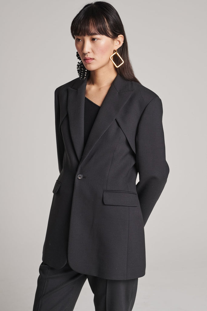 Shoulder-padded fitted blazer. Features a double layer at the front top panel and back. True to size.