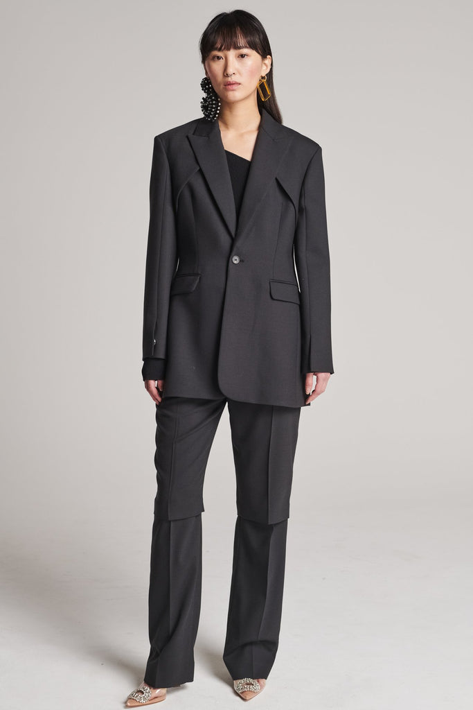 Shoulder-padded fitted blazer. Features a double layer at the front top panel and back. True to size.