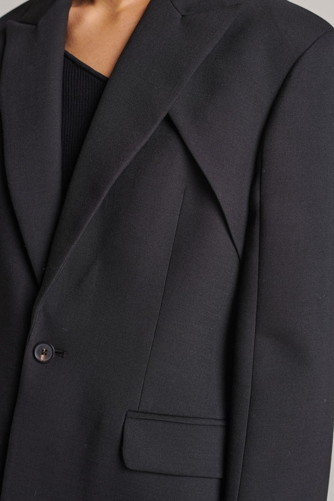 Shoulder-padded fitted blazer. Features a double layer at the front top panel and back. True to size.