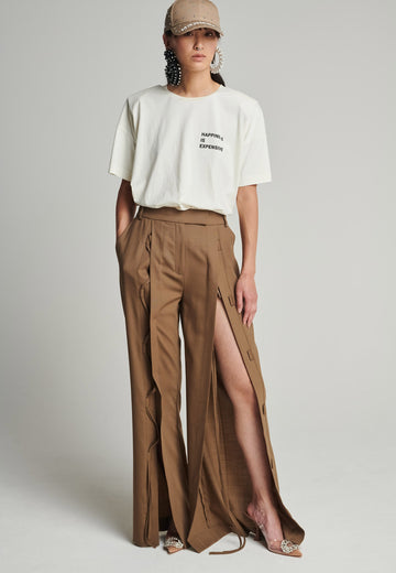 Wide-leg braided pants in camel. Features pockets, belt loops, and deep openings connected by strings. Fits oversize.
