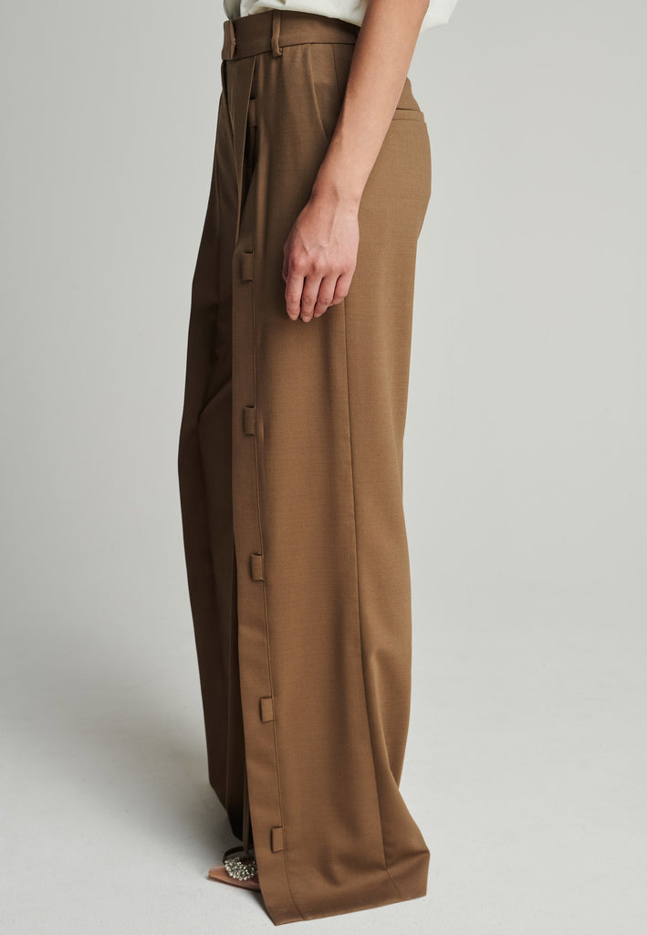 Wide-leg braided pants in camel. Features pockets, belt loops, and deep openings connected by strings. Fits oversize.