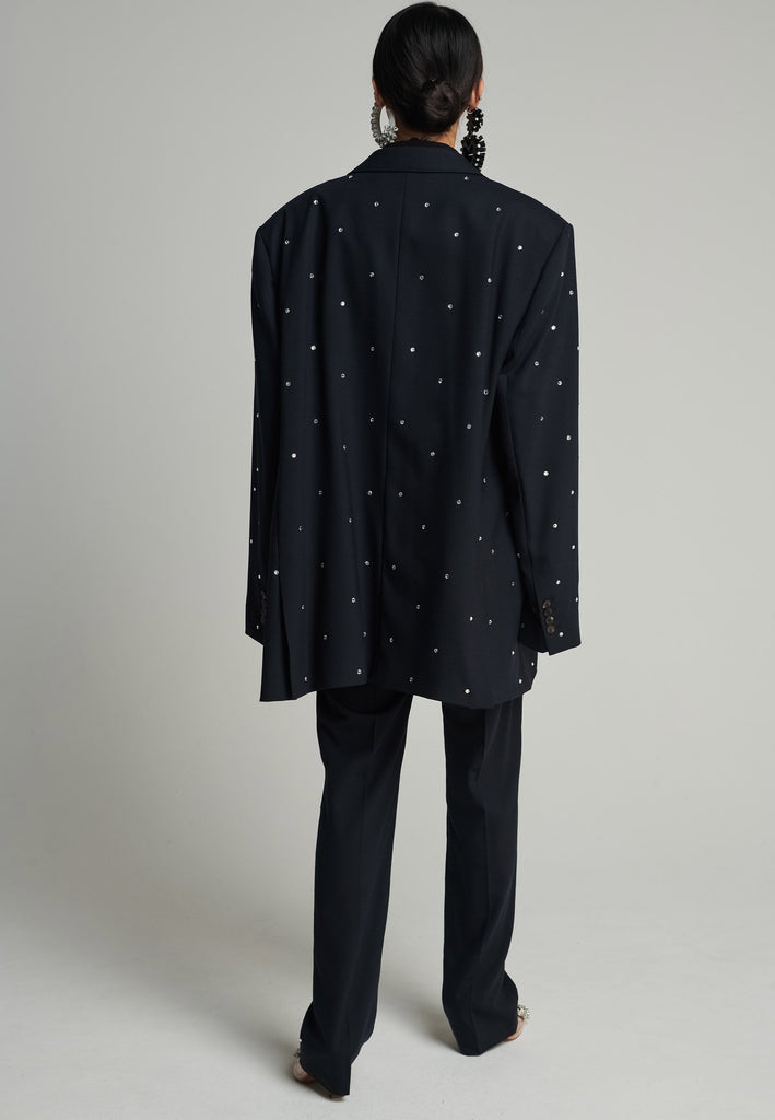 Wide-shouldered blazer in navy. Features sprinkled Swarovski diamonds, shoulder pads, pockets, and exaggerated long sleeves. Fits super oversize.