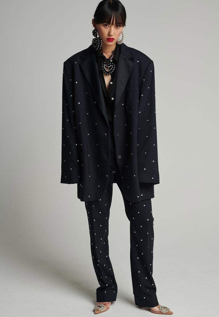 Wide-shouldered blazer in navy. Features sprinkled Swarovski diamonds, shoulder pads, pockets, and exaggerated long sleeves. Fits super oversize.