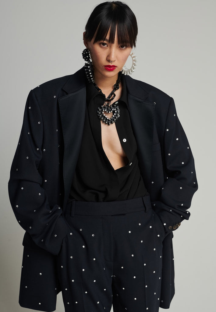 Wide-shouldered blazer in navy. Features sprinkled Swarovski diamonds, shoulder pads, pockets, and exaggerated long sleeves. Fits super oversize.