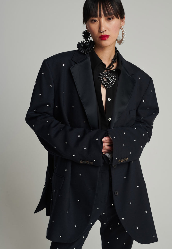 Wide-shouldered blazer in navy. Features sprinkled Swarovski diamonds, shoulder pads, pockets, and exaggerated long sleeves. Fits super oversize.