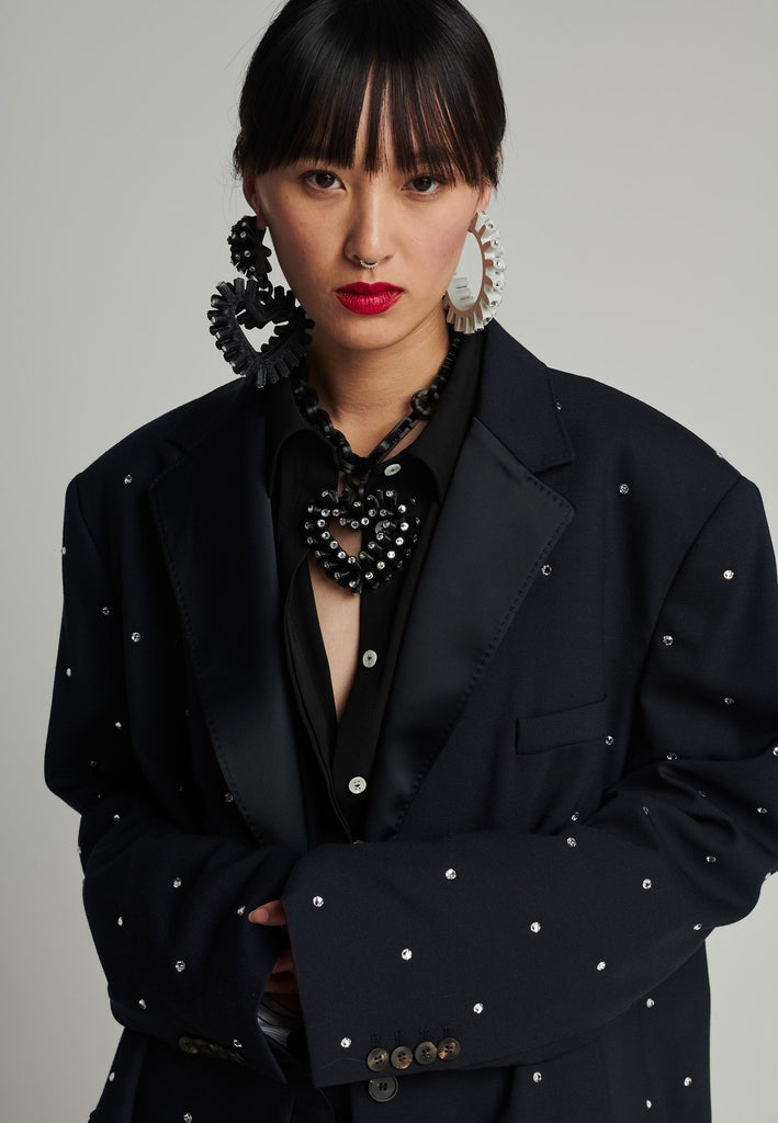 Wide-shouldered blazer in navy. Features sprinkled Swarovski diamonds, shoulder pads, pockets, and exaggerated long sleeves. Fits super oversize.